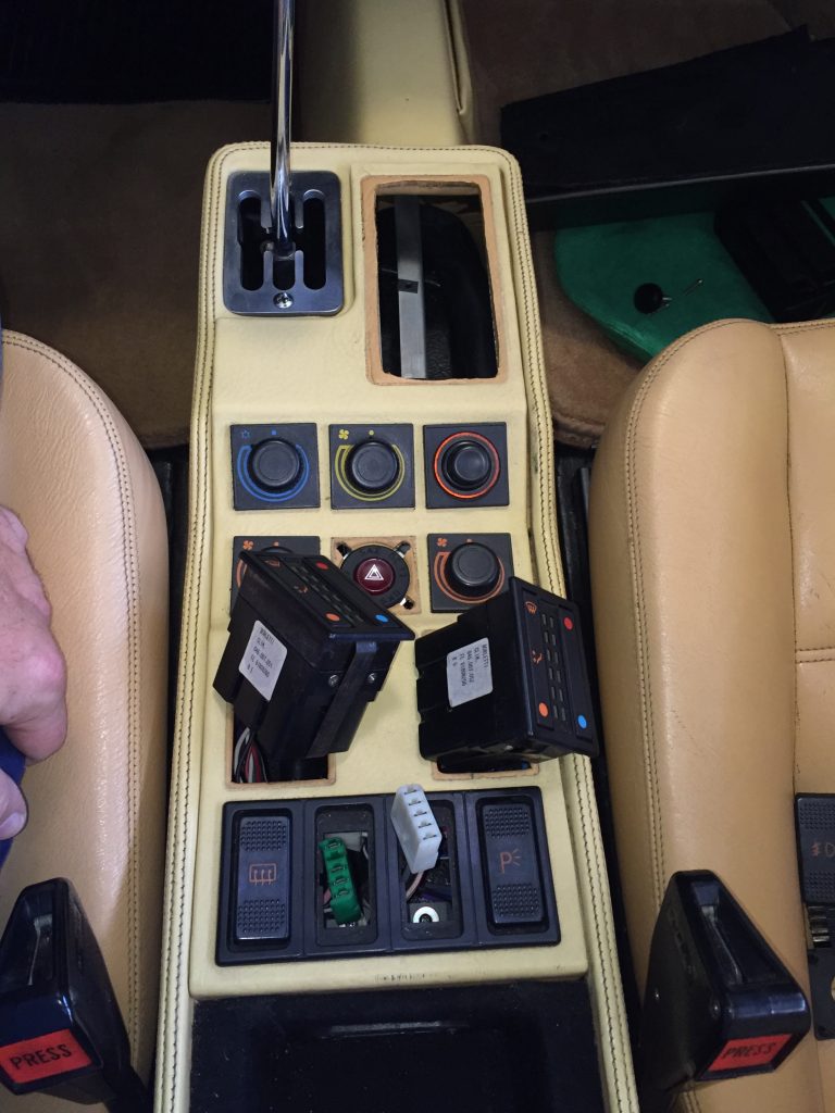 Ferrari 328 console switches removed to access the last two screws that secure it
